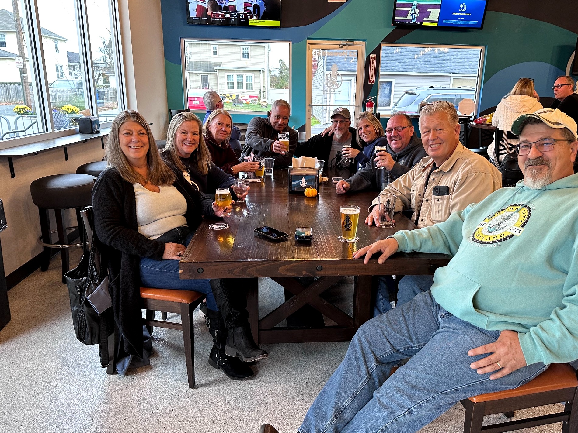 Friends gathering around a table at Watchtower Brewing