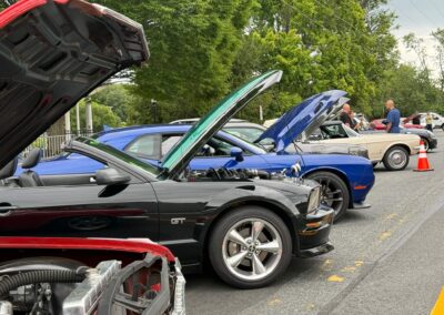 Classic cars with hoods raised at Watchtower Cruise Night